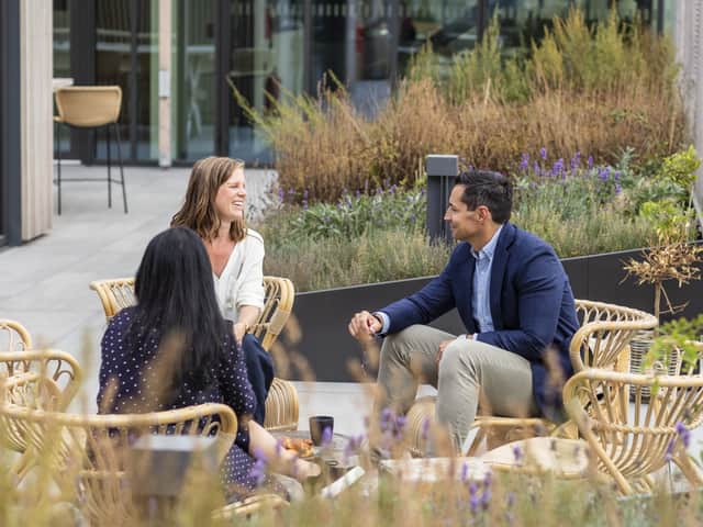 Three people sitting outside talking.